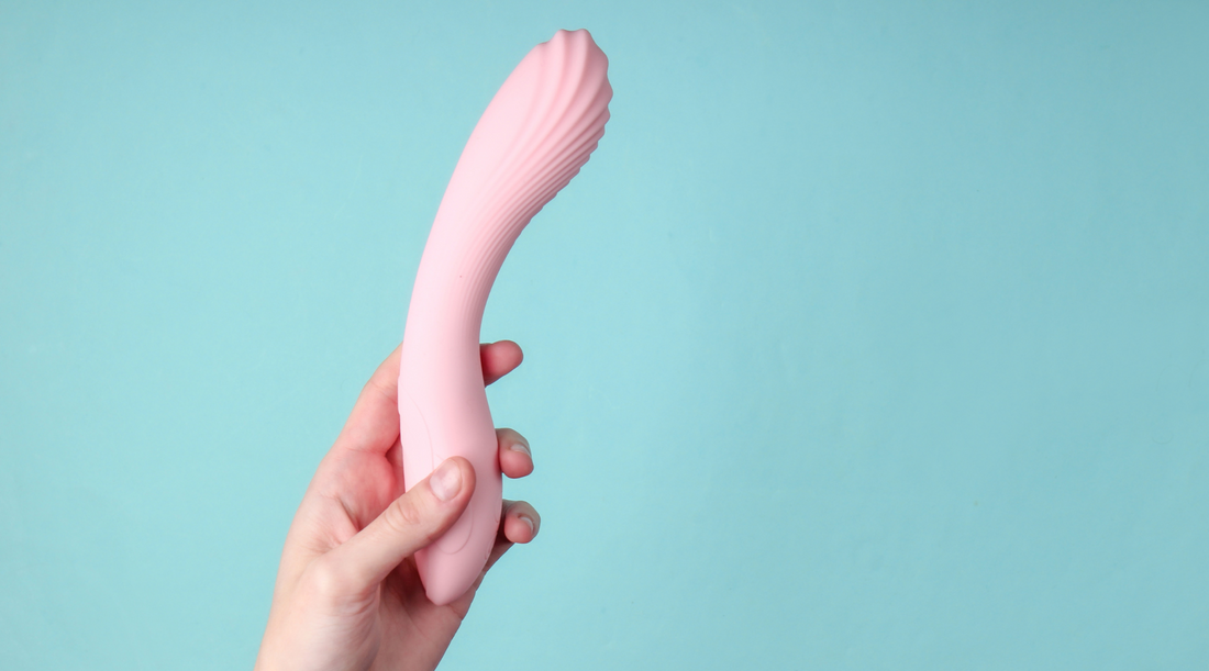 Woman in bedroom holding vibrator in hand – Ecsta Care