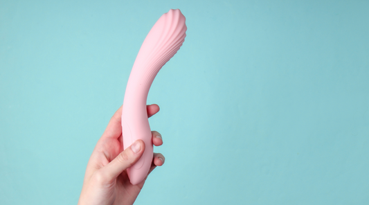 Woman in bedroom holding vibrator in hand – Ecsta Care